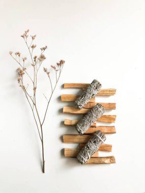 Palo santo ve beyaz adaçayı, aromaterapi ve beyaz arka planda tütsü. Metin yeri, dinsel minimalist arkaplan
