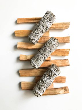 Palo santo ve beyaz adaçayı, aromaterapi ve beyaz arka planda tütsü. Metin yeri, dinsel minimalist arkaplan