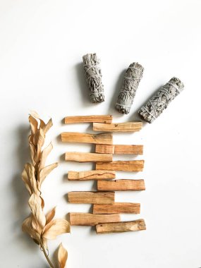 Palo santo ve beyaz adaçayı, aromaterapi ve beyaz arka planda tütsü. Metin yeri, dinsel minimalist arkaplan