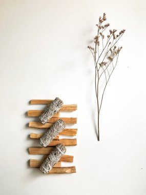 Palo santo ve beyaz adaçayı, aromaterapi ve beyaz arka planda tütsü. Metin yeri, dinsel minimalist arkaplan