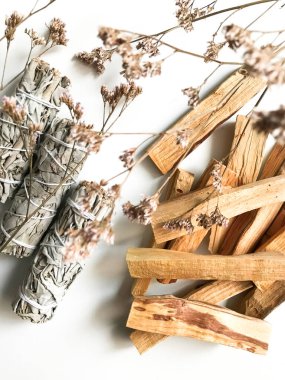 Palo santo ve beyaz adaçayı, aromaterapi ve beyaz arka planda tütsü. Metin yeri, dinsel minimalist arkaplan