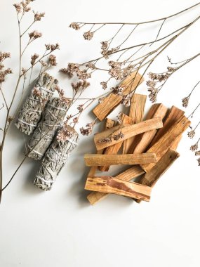 Palo santo ve beyaz adaçayı, aromaterapi ve beyaz arka planda tütsü. Metin yeri, dinsel minimalist arkaplan