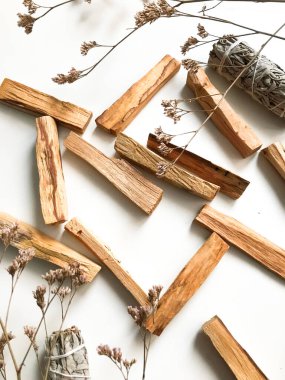 Ahşap palo santo sopalarının, aromaterapinin ve beyaz arka plandaki aromaların büyüsünün çok güzel bir arka planı var. Işık görüntüsü bulanıklaşması, odak eksikliği, yumuşak doku kombinasyonları.
