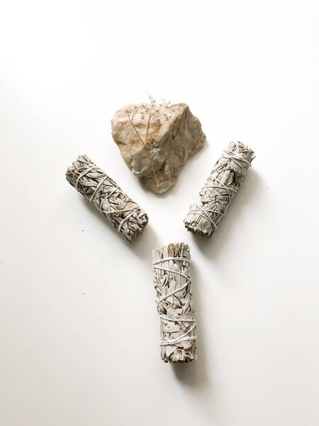 bunches of white California sage on a white background, minimalism and a place for text. sacred incense, aromatherapy and meditation