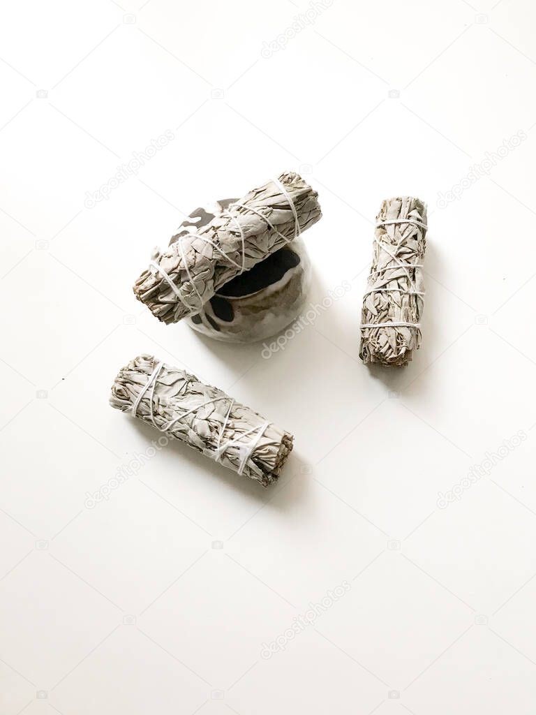 bunches of white California sage on a white background, minimalism and a place for text. sacred incense, aromatherapy and meditation