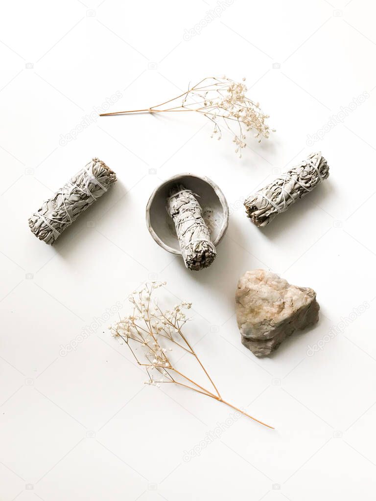bunches of white California sage on a white background, minimalism and a place for text. sacred incense, aromatherapy and meditation