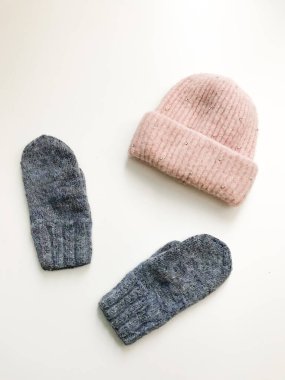 Beyaz arka planda sıcak kış eldivenleri ve boneler. Estetik minimalist kavram. Düz yatıyordu, üst görünüm moda kalıpları