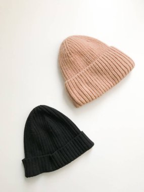 Beyaz arka planda sıcak kış eldivenleri ve boneler. Estetik minimalist kavram. Düz yatıyordu, üst görünüm moda kalıpları