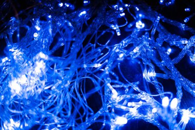 Yeni yılın mavi çelenklerinin çok soyut bir görüntüsü. Ampulleri, güçlü bulanıklığı ve yumuşak odağı var.