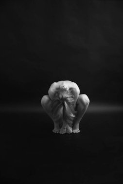 Athletic nude woman body on dark background. Fine-art photo of nude woman body.