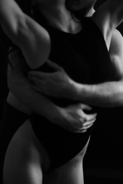Sensual touches between a man and a woman, a beautiful fashion portrait of a couple, body details with a slight element of eroticism. A place for text and a blurred fleur of love