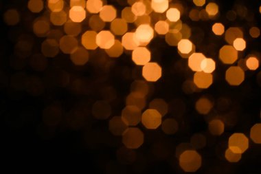 Turuncu Bokeh 'in soyut geçmişi, yeni yıl konsepti. Bulanık odak içinde küçük ışıklar