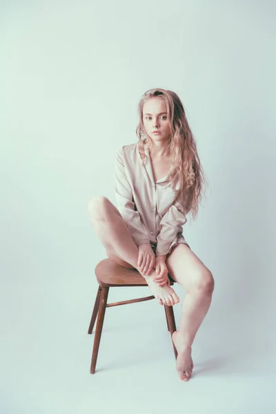 Eine Schöne Blondine Mit Langen Haaren Und Puppenartigem Aussehen Sitzt — Stockfoto
