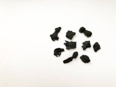 Beyaz arka planda koyu tütsü reçinesi, küçük reçine parçalarının aroması.