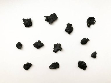 Beyaz arka planda koyu tütsü reçinesi, küçük reçine parçalarının aroması.