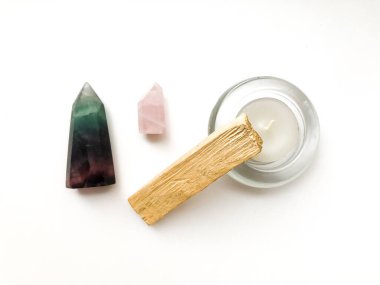 Palo santo tütsü çubuğu meditasyon için, mum ve gül kuvars kristali beyaz arka planda, metin için yer, üst görünüm için