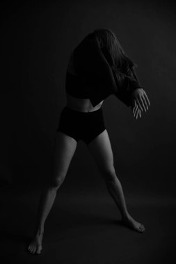 İç çamaşırlı bir kızın bulanık silüeti, yumuşak odaklı gri arka plan.