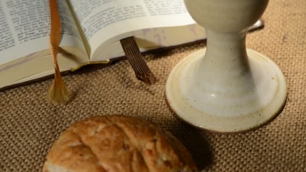 Библия с чашей и хлебом — стоковое видео