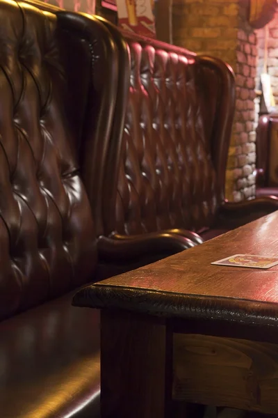 Mesa de madera y cómodos asientos en el pub — Foto de Stock