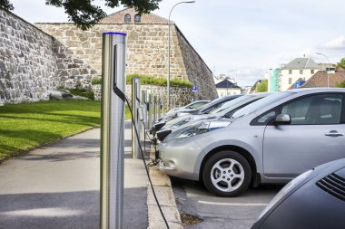 Electric car plugged in to electricity clipart