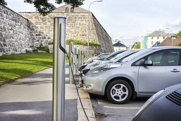 Elbilen ansluten till Elηλεκτρικό αυτοκίνητο στην πρίζα στην ηλεκτρική ενέργεια — Φωτογραφία Αρχείου