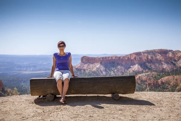 Jeune femme jouissant de la nature sur un banc — Photo