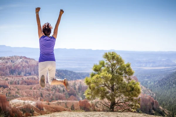 Młoda kobieta radośnie skoki w parku bryce canyon — Zdjęcie stockowe