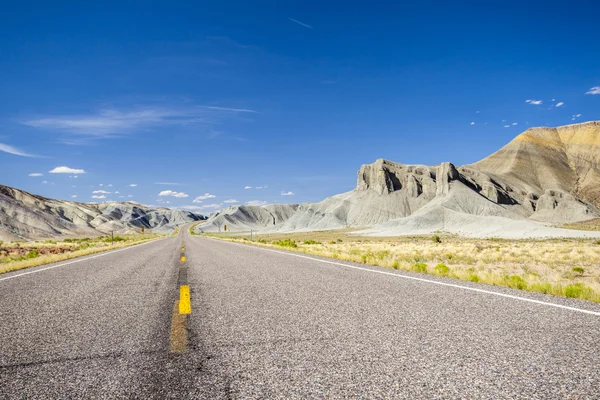 Asphalt road through grey mountains — Stock Photo, Image