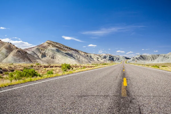 Camino de asfalto a través de montañas grises —  Fotos de Stock