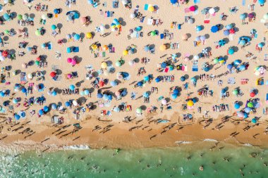 Birçok insanın deniz ve kumsalın tadını çıkardığı insansız hava aracı görüntüleri. Tatil modelleri. Portekiz, Portimao 'daki Rocha Plajı