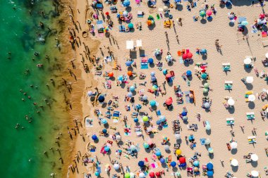 Birçok insanın deniz ve kumsalın tadını çıkardığı insansız hava aracı görüntüleri. Tatil modelleri. Portekiz, Portimao 'daki Rocha Plajı