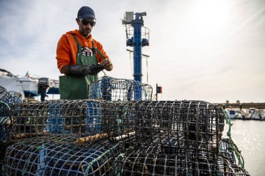 Alvor, Portekiz - 28 Ekim 2021 Balıkçı yerel limandaki ahtapot tuzaklarının içine yengeç koydu