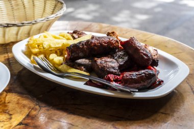 Sosis, dana eti ve domuz eti ızgara ve patates kızartmasıyla servis ediliyor.