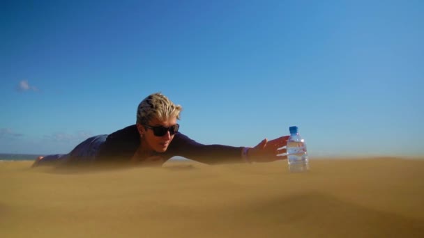 砂漠の水のボトルに必死に手を差し伸べている女性 — ストック動画