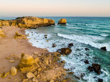Günbatımında Atlantik Okyanusu kıyısındaki Sao Rafael sahilindeki uçurumların havadan görünüşü, Algarve, Portekiz