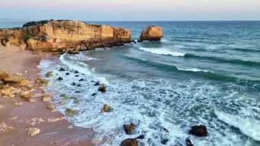 Günbatımında Atlantik Okyanusu kıyısındaki Sao Rafael sahilindeki uçurumların havadan görünüşü, Algarve, Portekiz