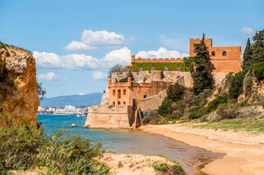 Kumlu sahil şeridi ve Ferragudo, Algarve, Portekiz 'deki Sao Joao kalesi.