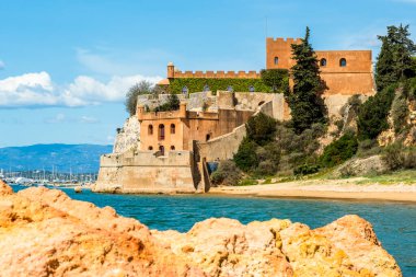 Kumlu sahil şeridi ve Ferragudo, Algarve, Portekiz 'deki Sao Joao kalesi.