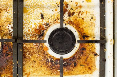 Kirli gaz sobası yüzeyi. Orta gaz ocağı ve eski yiyecek ve içeceklerle çevrili bir gaz fırınının demir ızgarası. Üst bölge yüzeyi ve kullan-at kafaların yanmış yağlardan temizlenmesi gerekiyor.