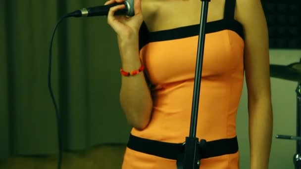 Una Hermosa Cantante Con Vestido Naranja Brillante Sostiene Micrófono Mano — Vídeos de Stock