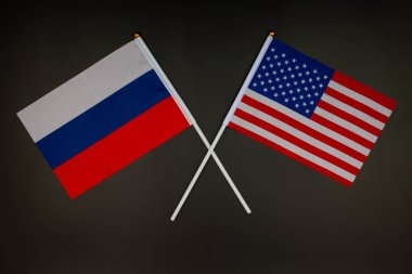 Rusya bayrağı ve ABD bayrağı siyah arka planda birbirleriyle çarpıştı. Rusya ABD 'ye karşı. Rusya ve Amerika Birleşik Devletleri başkanları arasında toplantı. İlişkilerde gerginlik. İzole edilmiş. Üst görünüm 