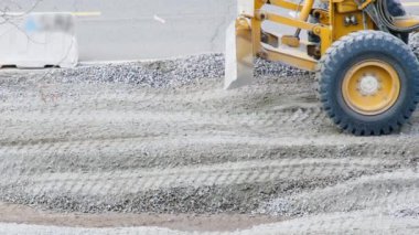 Not makinesi. Yol tamiri. Çift bıçaklı modern motor traktörü. Şehir caddesinde asfalt için zemin hazırlıyorum. Yol yapımı. Ağır ekipman makineleri. Ağır vasıtalar. Ezilmis taslar