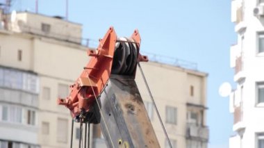 Mavi gökyüzüne ve yüksek binaya karşı halat çekme kulesi. Vinç Hawser 'ı. İnşa halatı vinç. Kablo kaldırma. İnşaat alanında inşaat malzemeleri. Kapat..