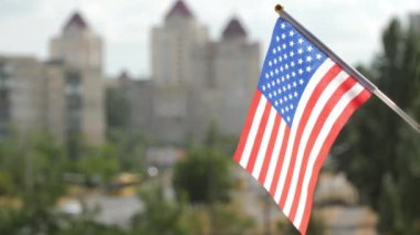 Amerika Birleşik Devletleri bayrağı mavi gökyüzüne, şehir caddesine ve binalara asıldı. Stars and Stripes Amerikan bayrağı. Amerikan bayrağı dalgalandırması. Amerika 'nın bayrağı güneşle aydınlandı. Boşluğu kopyala