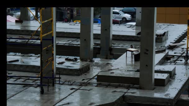 雨の中で建設現場 ビルダーは悪天候のために職場を去った コンクリートスラブと前の鉄筋コンクリート杭は水で浸水しています 労働者たちは強制休憩に入った — ストック動画