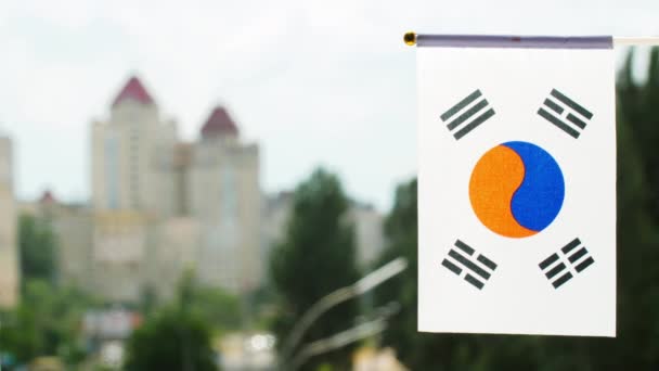 韓国の旗は青空 街の通りや建物に対して設定されます 韓国旗が振ってある 太陽に照らされた韓国の祝日の旗 朝鮮解放の日 テキストのコピースペース — ストック動画