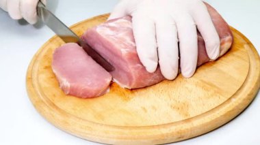 Aşçı ahşap bir kesme tahtasıyla taze bir parça domuz keser. Barbekü için et bifteği. Barbekü yemek hazırlığı. Mutfakta yemek pişirmek. Kebap için sağlıklı besin maddeleri. Yumuşak fileto diyeti. Yakın plan.