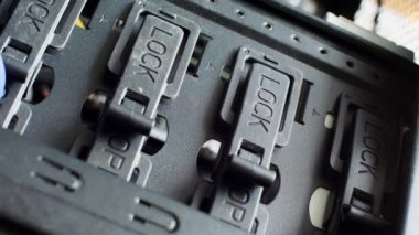 Mavi eldivenli bir el, Açık 'tan Kilit' e geçişi kapatır. Efendi elektronik kilitleri kapatıyor. Elektronik ekipmanın bir parçası. Bilgisayar sunucu odası. Plastik ve metal. Yakın plan.