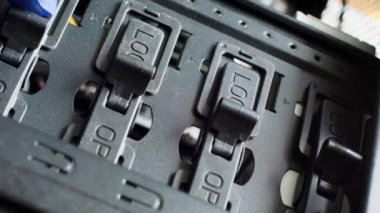 Mavi eldivenli bir el, Kilit 'ten Açık konuma geçiş anahtarlarını açar. Ana kapı elektronik kilitleri açıyor. Elektronik ekipmanın bir parçası. Bilgisayar sunucu odası. Plastik ve metal. Yakın plan.