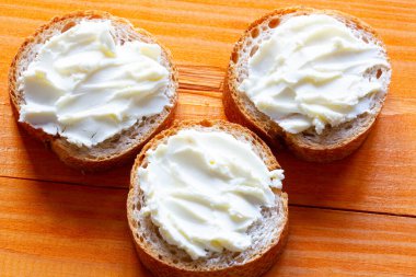 Masada krem peynirli sandviç. Yumuşak peynirli dilimlenmiş ekmek dilimleri. Taze Fransız ekmeğine yapıştır. Çay ve kahve için ev yapımı tatlı. Sabah kahvaltısı. Lezzetli yemek.